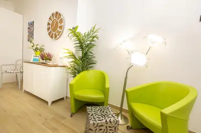 a living room with two green chairs and a lamp at Casa Libetta in Rome
