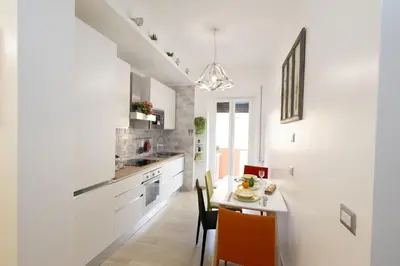 a kitchen with white cabinets and a table with chairs at Casa Libetta in Rome