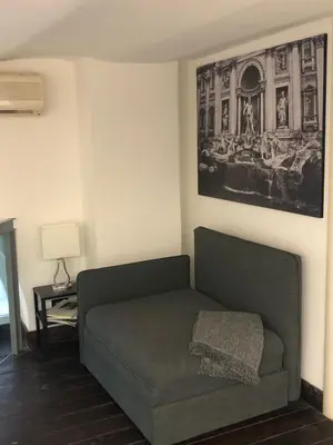 a couch in a living room with a picture on the wall at Loft in old town near Termini Station and University in Rome