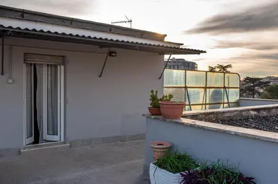 a white house with potted plants on a balcony at DODO Casa e appartamento per vacanze in Rome