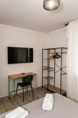 a room with a table and a desk with a television at DODO Casa e appartamento per vacanze in Rome