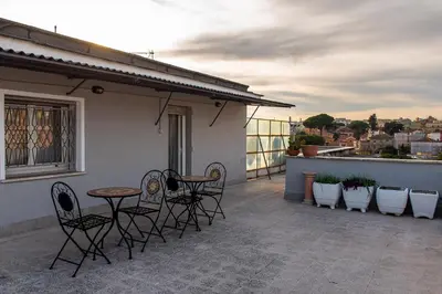 a patio with chairs and a table on a balcony at DODO Casa e appartamento per vacanze in Rome