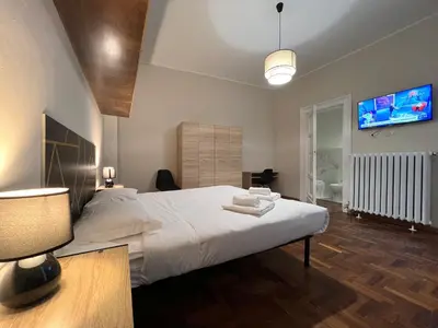 a bedroom with a large white bed and a flat screen tv at Marbel's Rooms in Rome