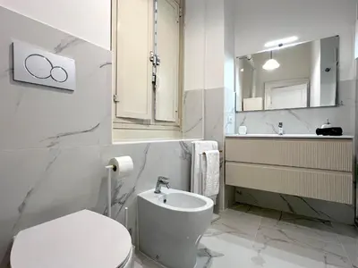 a white bathroom with a toilet and a sink at Marbel's Rooms in Rome