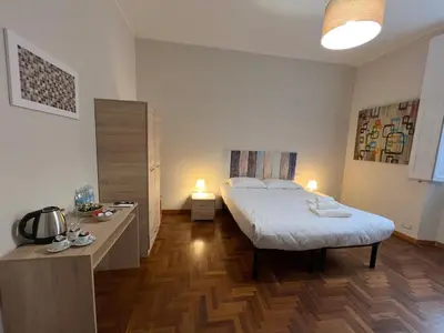 a bedroom with a bed and a desk with two lights at Marbel's Rooms in Rome