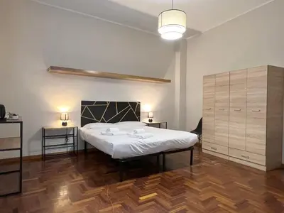 a bedroom with a large bed and two night stands at Marbel's Rooms in Rome