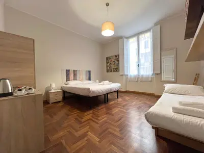a bedroom with two beds and a wooden floor at Marbel's Rooms in Rome