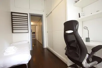a room with a black chair and a bed at Cipro 2BR Holiday House in Rome