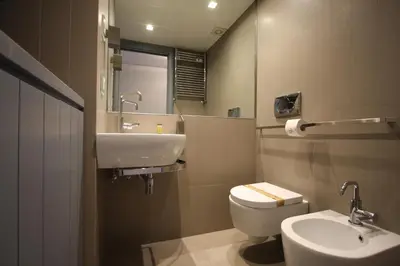a bathroom with a sink and a toilet and a mirror at Cipro 2BR Holiday House in Rome