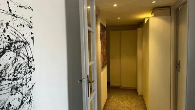 a hallway with an open door with a painting on the wall at The attic in Rome