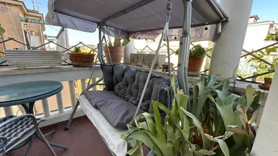 a couch sitting under an umbrella on a balcony at The attic in Rome