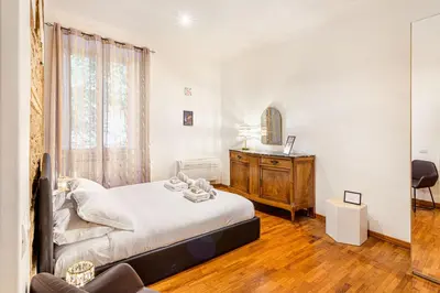 a bedroom with a bed and a dresser and a mirror at Giulia Apartment in Rome