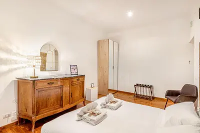 a bedroom with two beds and a dresser and a mirror at Giulia Apartment in Rome