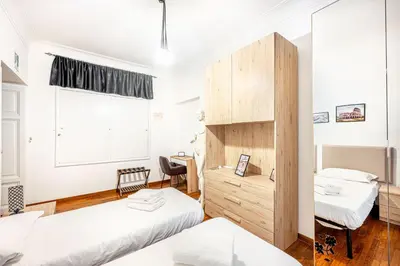 a bedroom with two beds and a desk and a window at Giulia Apartment in Rome