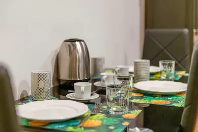 a table with plates and cups and a coffee maker at Giulia Apartment in Rome
