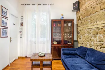 a living room with a blue couch and a stone wall at Giulia Apartment in Rome