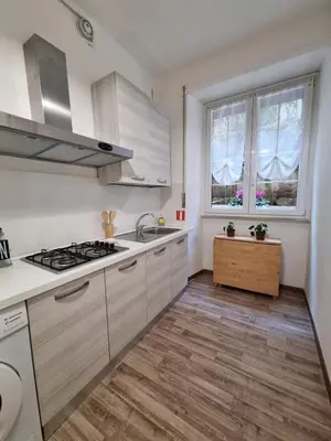 a kitchen with white cabinets and a stove and a window at Papa's House - Re di Roma in Rome