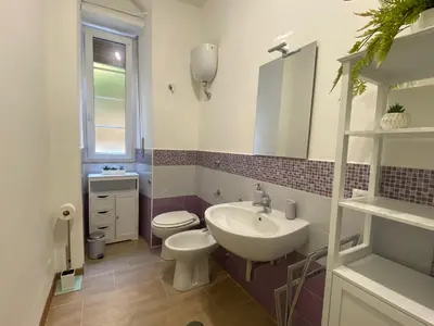a bathroom with a sink and a toilet and a mirror at Papa's House - Re di Roma in Rome