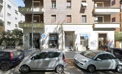 two cars parked in a parking lot in front of a building at Papa's House - Re di Roma in Rome