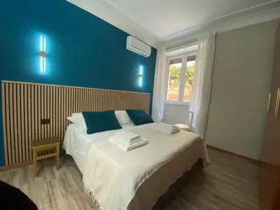 a bedroom with a large bed with blue walls at Papa's House - Re di Roma in Rome