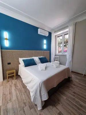 a bedroom with a large bed with a blue wall at Papa's House - Re di Roma in Rome