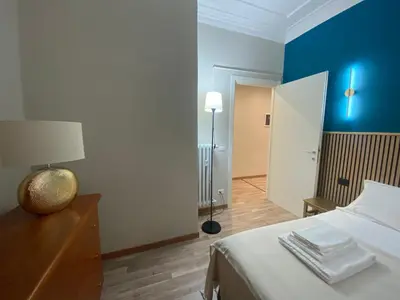 a bedroom with a bed and a blue wall at Papa's House - Re di Roma in Rome