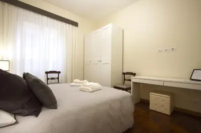 a bedroom with a bed with a desk and a mirror at Contessa 3BR Holiday House in Rome