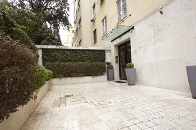 a walkway leading to a building with a hedge at Contessa 3BR Holiday House in Rome