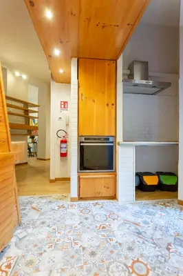 a kitchen with wooden cabinets and a stove at Oliviero - Colosseo Apartment with Terrace in Rome