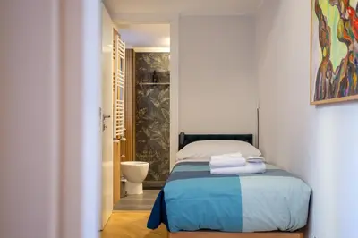 a bedroom with a bed and a bathroom with a toilet at Oliviero - Colosseo Apartment with Terrace in Rome