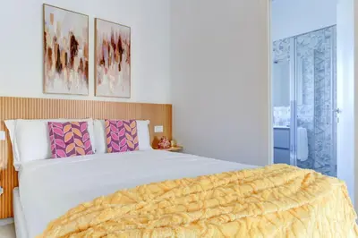 a bedroom with a large white bed with a yellow blanket at Vatican Loft with Balcony - Home and More in Rome