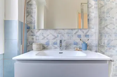 a bathroom with a white sink and a mirror at Vatican Loft with Balcony - Home and More in Rome