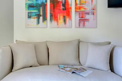 a couch with pillows and paintings on the wall at Vatican Loft with Balcony - Home and More in Rome