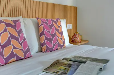 a bed with two pillows and a magazine on it at Vatican Loft with Balcony - Home and More in Rome