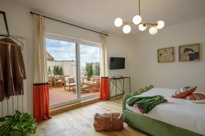 a bedroom with a bed and a balcony with a table at Daplace - Costanza Apartment in Rome
