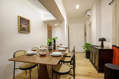 a dining room with a wooden table and chairs at Daplace - Costanza Apartment in Rome