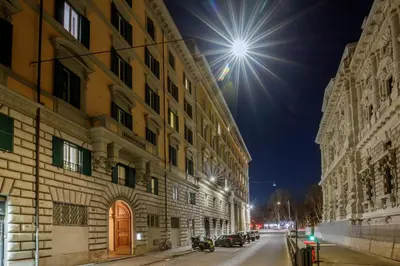 a street at night with a building and cars at Daplace - Costanza Apartment in Rome