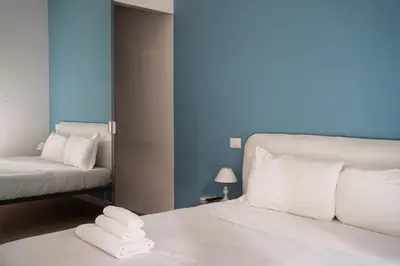 a bedroom with a white bed and a night stand with a lamp at Loft Aurelia 336 in Rome