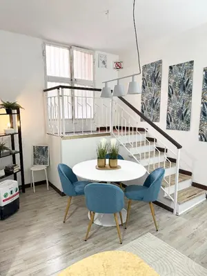 a dining room with a white table and blue chairs at VOLUPTA' S HOUSE in Rome MANZONI - COLOSSEO in Rome