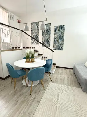a living room with a table and chairs and a bed at VOLUPTA' S HOUSE in Rome MANZONI - COLOSSEO in Rome