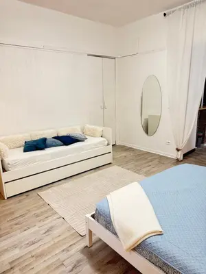 a white room with a couch and a mirror at VOLUPTA' S HOUSE in Rome MANZONI - COLOSSEO in Rome