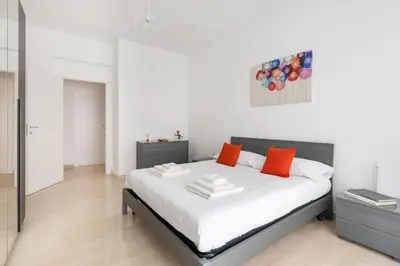 a bedroom with a large white bed with orange pillows at Lacasadigió in Rome