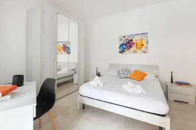 a white bedroom with a bed and a mirror at Lacasadigió in Rome