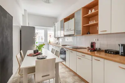 a kitchen with white cabinets and a table and chairs at Lacasadigió in Rome