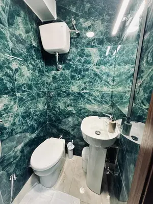 a green marble bathroom with a toilet and sink at Viktoria House Rome in Rome