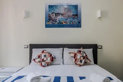 a bed with white pillows and a picture on the wall at Viktoria House Rome in Rome