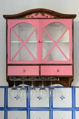a pink cabinet with wine glasses hanging from it at Center Suite Garbatella in Rome