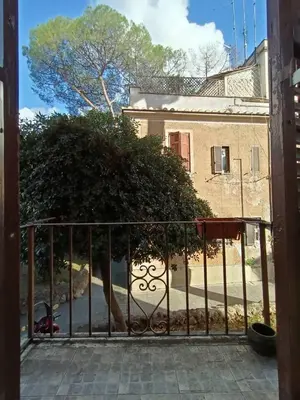 a gate in front of a building with a tree at Center Suite Garbatella in Rome
