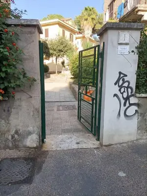 a gate with graffiti on the side of a building at Center Suite Garbatella in Rome