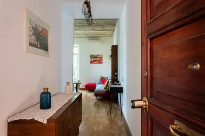 a hallway with a wooden door and a living room at Center Suite Garbatella in Rome